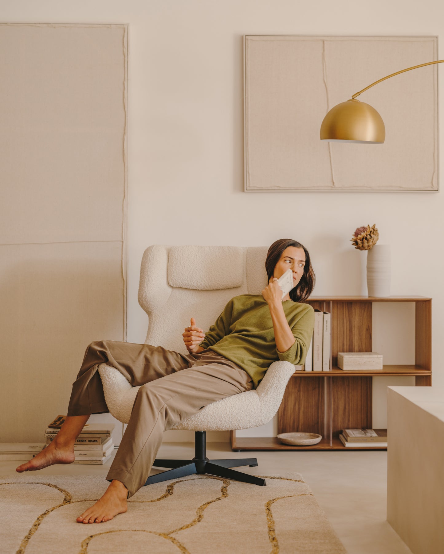 Poltrona girevole con braccioli Zalina di tessuto bouclé bianco e acciaio con finitura nera