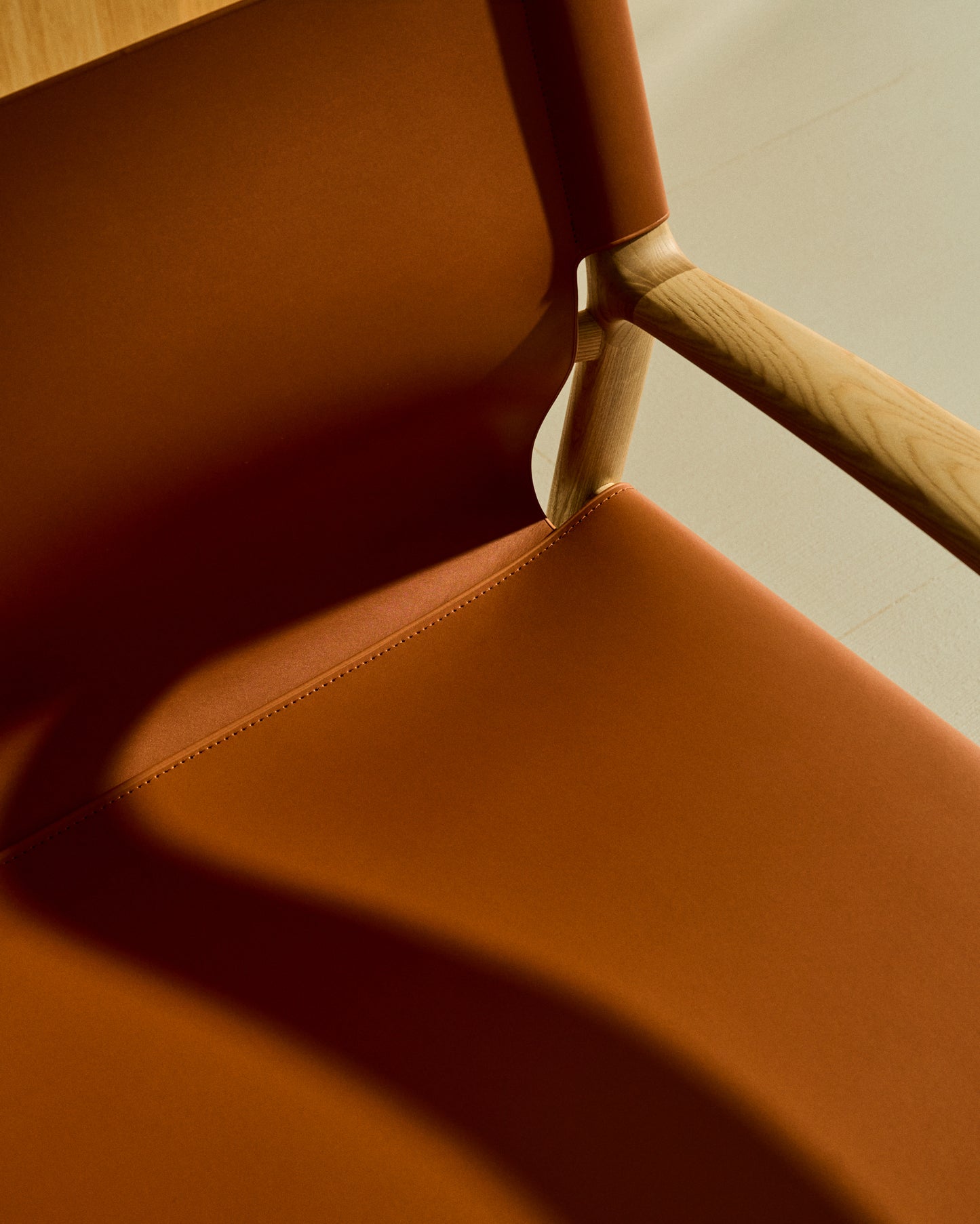 Poltrona Jan realizzata in fibre di cuoio riciclato marrone chiaro e legno massiccio di frassino con finitura in tono naturale