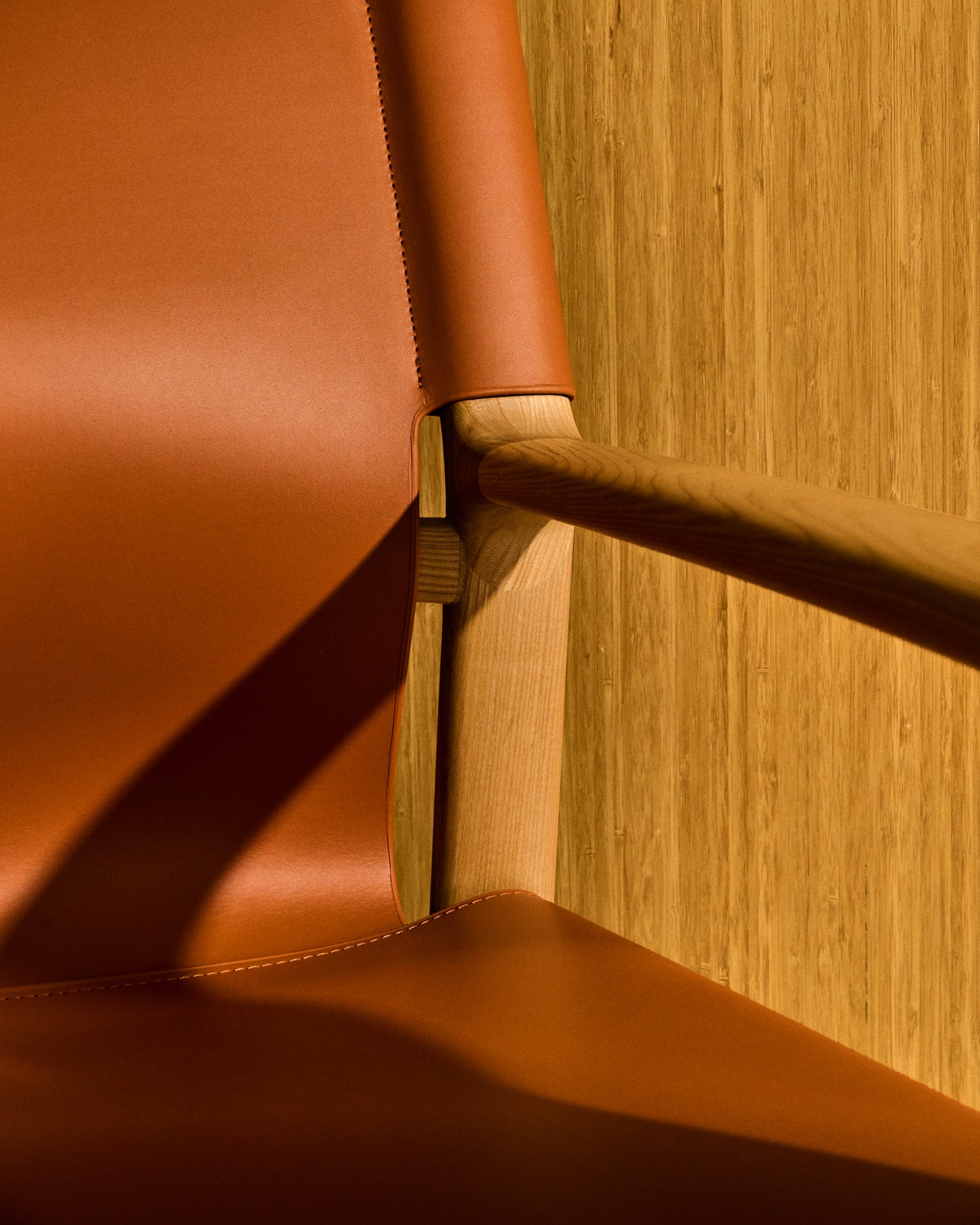 Poltrona Jan realizzata in fibre di cuoio riciclato marrone chiaro e legno massiccio di frassino con finitura in tono naturale