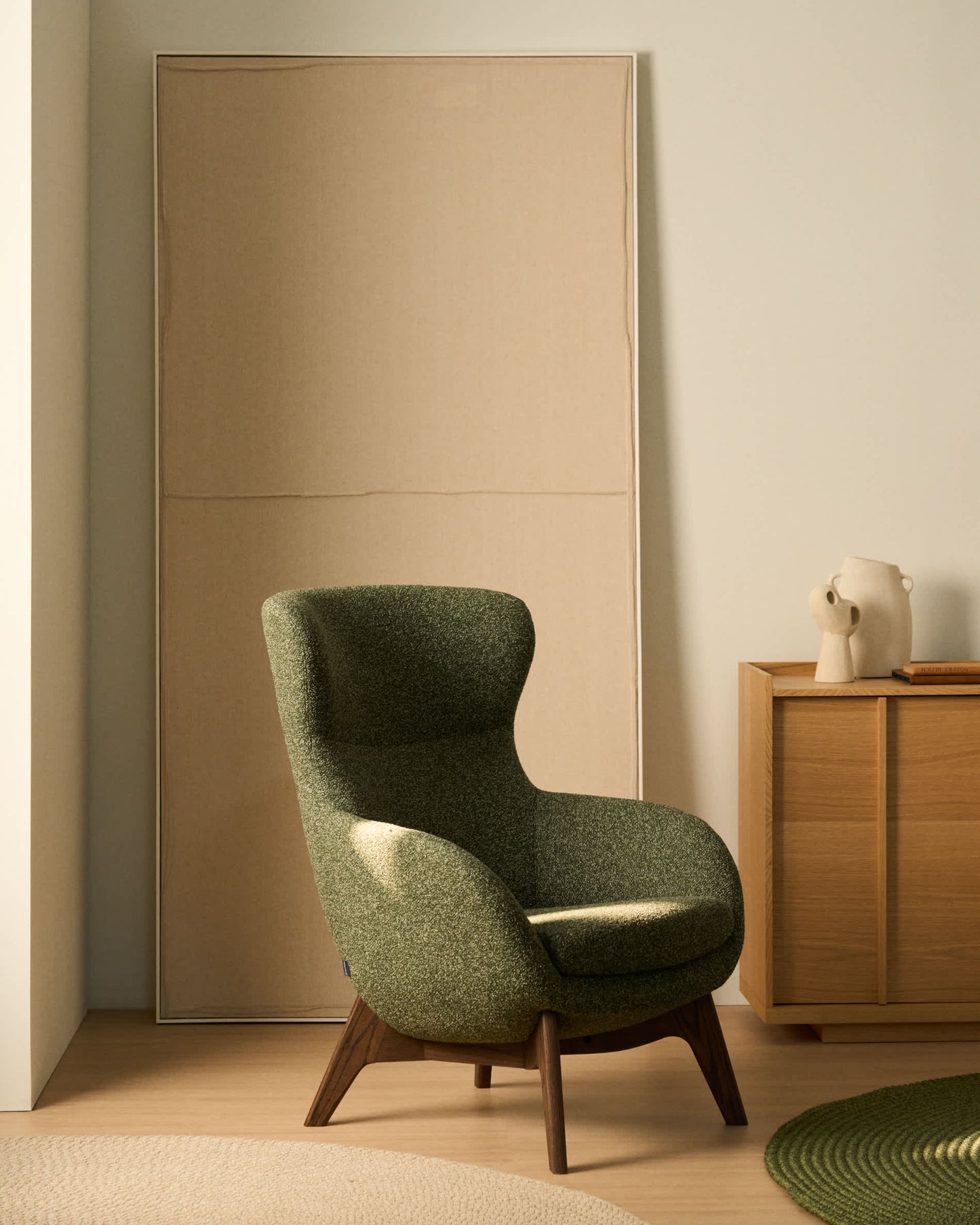 Poltrona Adiran in ciniglia spessa verde muschio con gambe in legno massiccio di rovere con finitura noce
