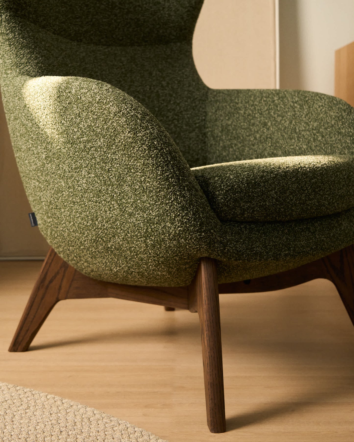 Poltrona Adiran in ciniglia spessa verde muschio con gambe in legno massiccio di rovere con finitura noce